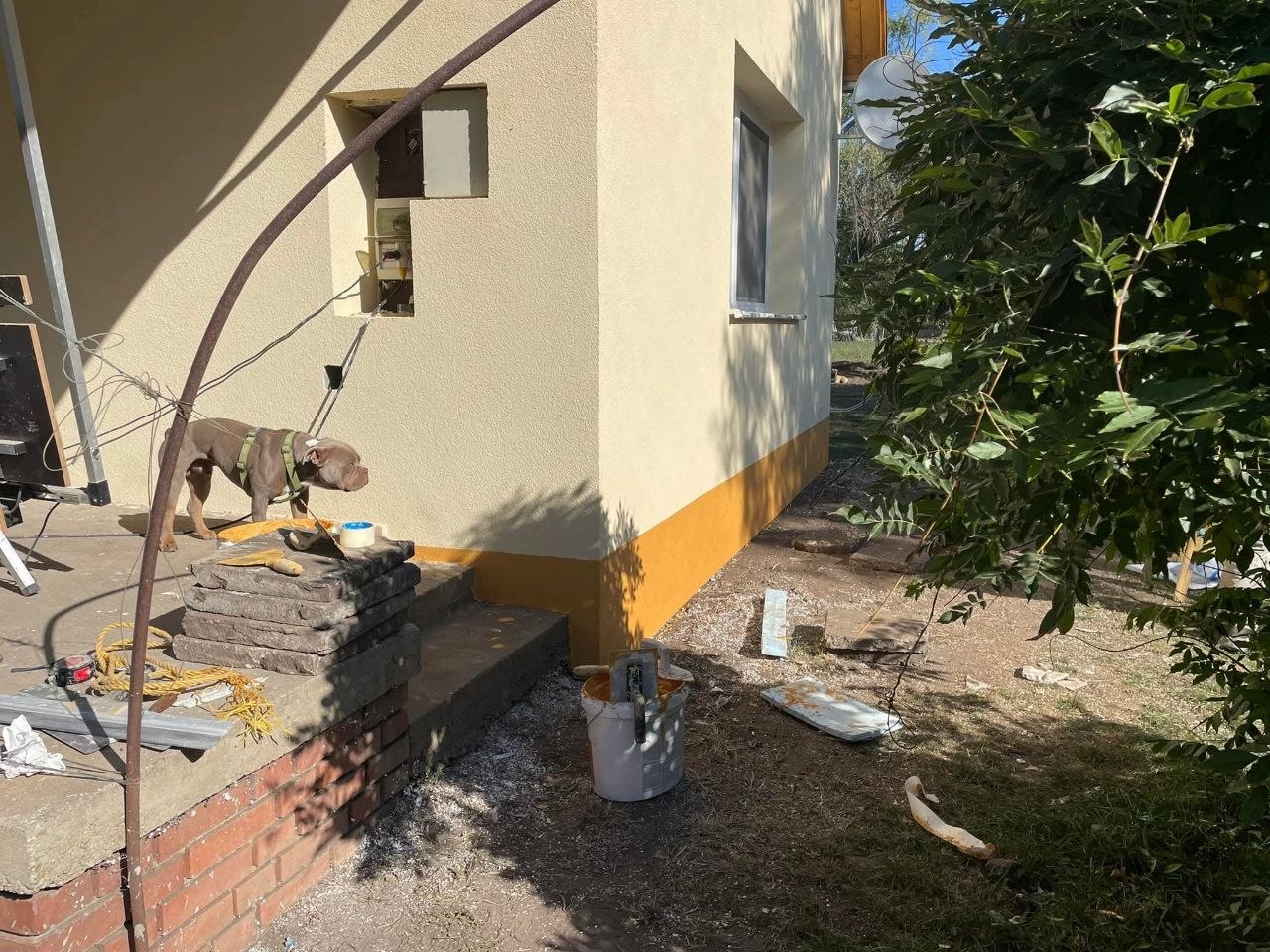 A ház sarka az elkészült homlokzattal és a sárga lábazattal